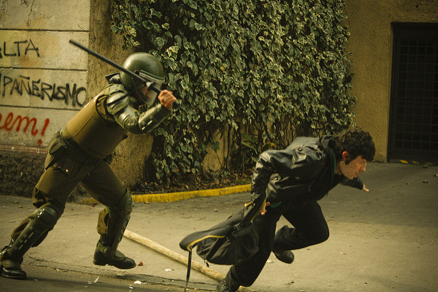 Granadero reprimiendo manifestante