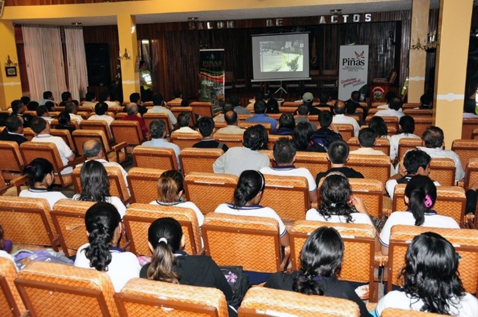 grupo de personas en un auditorio, escuchando una plática de inducción.