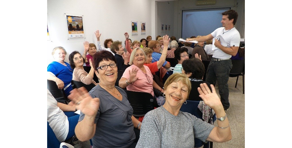 grupo de personas de una empresa sonriendo y saludando a la cámara.