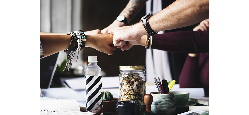 Equipo de trabajo chocando puños