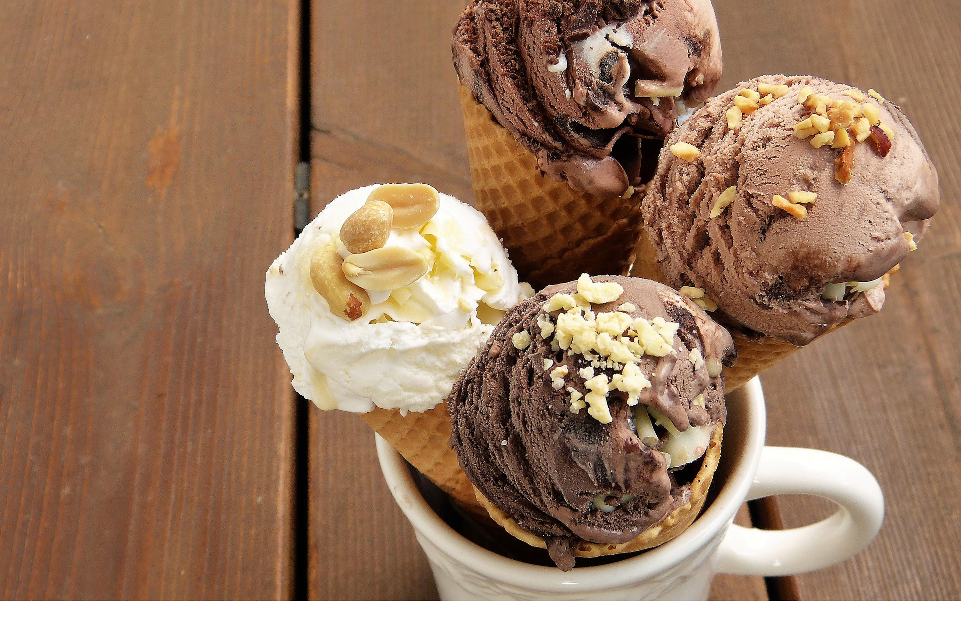 Fotografía de cuatro conos de helado insertados en una taza blanca.