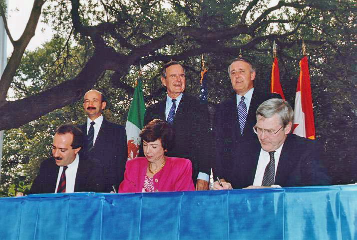 Fotografía de la ceremonia de iniciación del TLCAN de 1992, con los presidentes, secretarios de comercio, ministros de comercio, representante de comercio de Canadá, Estados Unidos y México. 