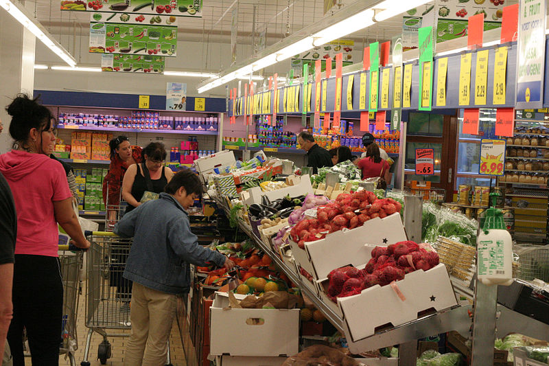 Supermercado donde los consumidores comparan el precio de frutas y verduras con la calidad