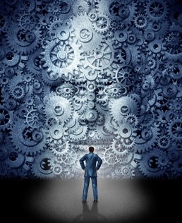 Hombre mirando una pared con engranes.