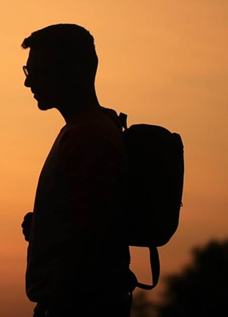 Silueta de un hombre que observa algo con detenimiento.