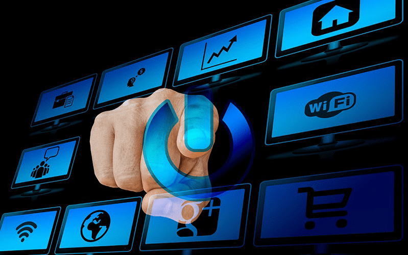 Composición de monitores con mano que oprime botón de encendido