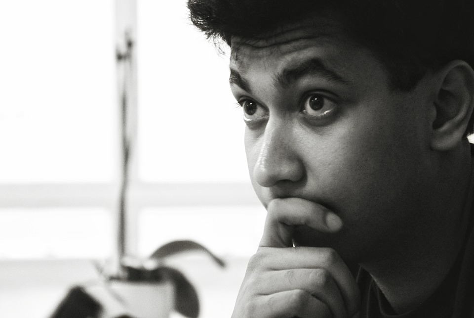 Imagen de joven en posición de reflexión.