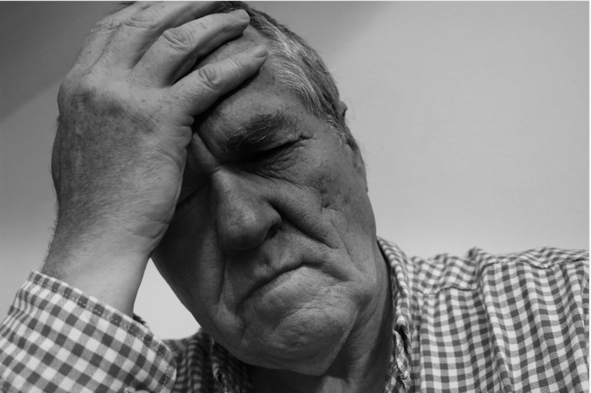 Adult man holding his head.
