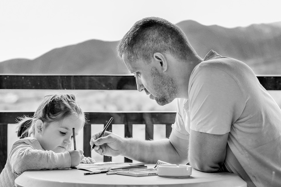  papá ayudando a su hija en su tarea escolar.