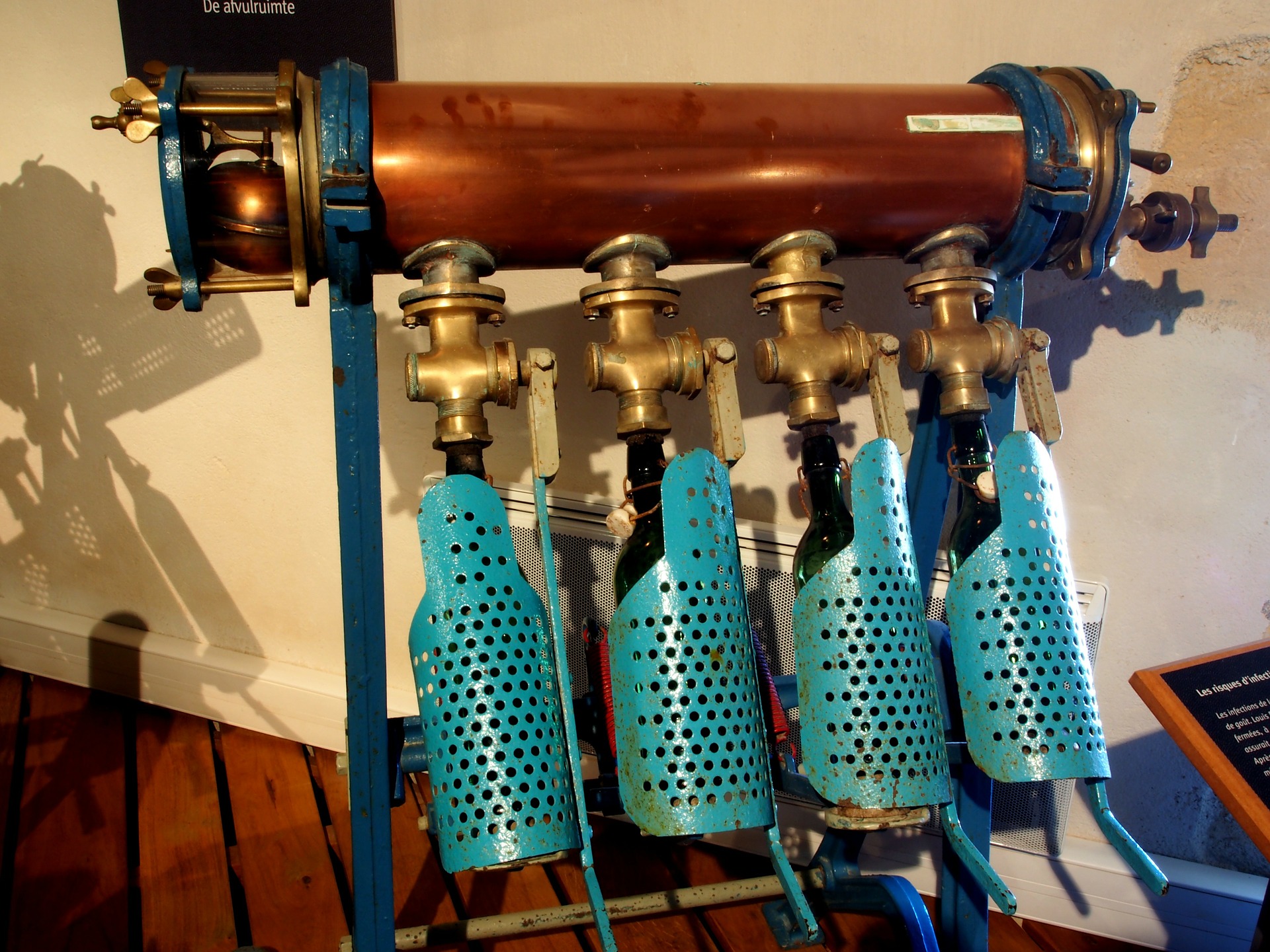 Máquina industrial embotellando tres envases de cerveza