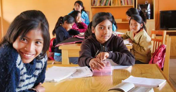 Niñas aprendiendo colaborativamente en mesas de estudio