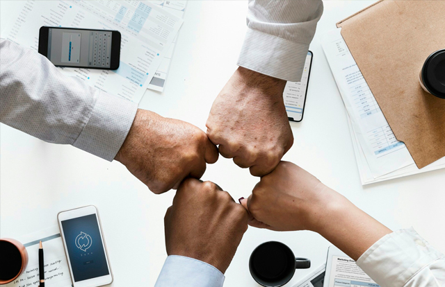 Personas juntando sus puños