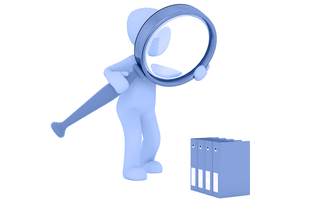 Persona revisando documentos con una lupa