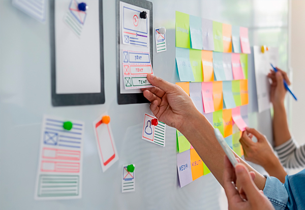 Personas adquiriendo experiencia tras realizar una actividad con post it